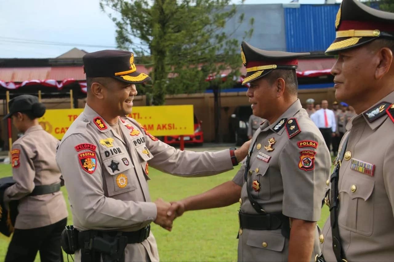 Kapolres Jayapura AKBP Dionisius Helan saat menyematkan tanda jabatan kepada Wakapolres Jayapura Kompol Suheriyono