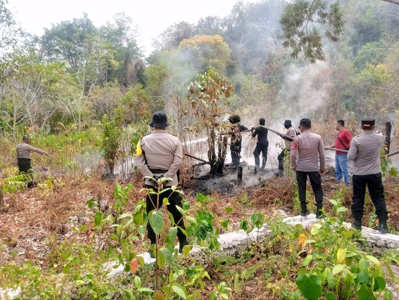 Polisi saat membantu memadamkan kebakaran hutan dan lahan