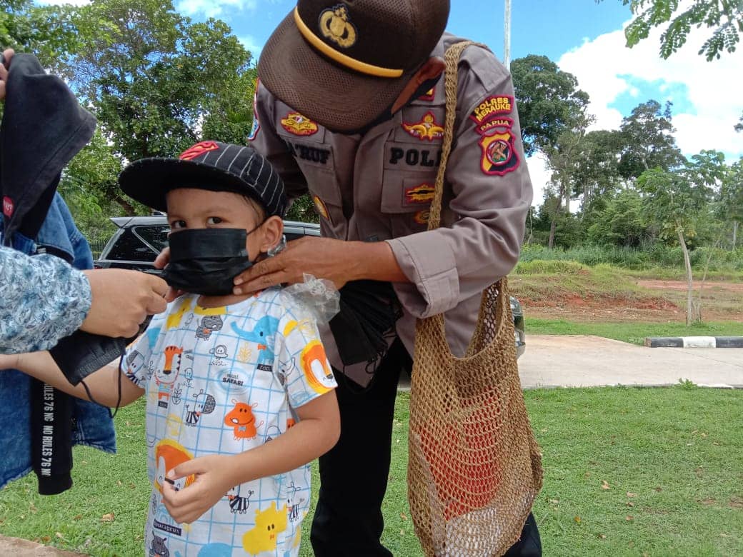 Kapolsek Sota, AKP Makruf Soeroto memasang masker kepada pengunjung PLBN Sota.