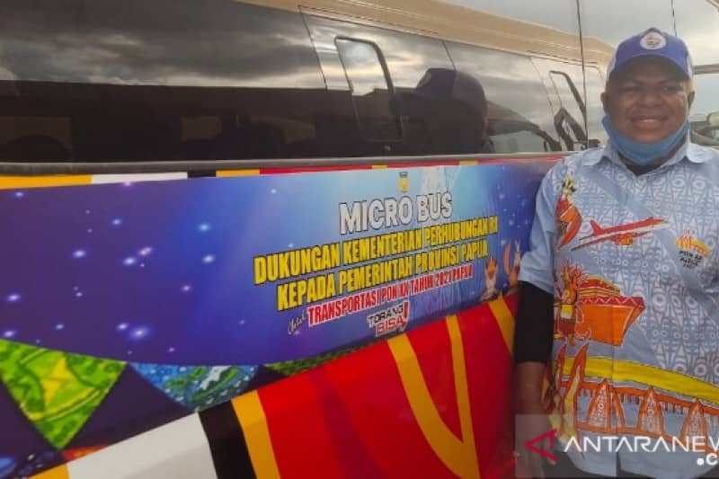 Naomi Demotekay berpose di depan minibus yang dikendarainya untuk mengangkut atlet dan ofisial PON XX