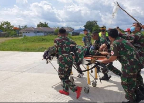 Pendam XVII Cenderawasih Petugas Lanud Yohanes Kapiyau saat membantu menurunkan Prada Giyade Ramadhani Fattah dari helikopter.