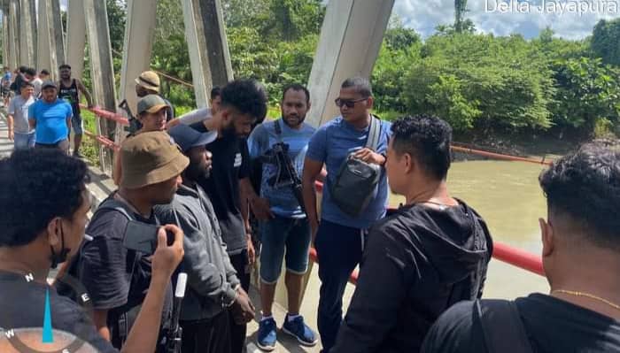 Foto: Istimewa Personil Polresta Jayapura saat menggiring tersangka NK ke Jembatan Kali Tami untuk menunjukkan lokasi pembuangan jasad korban.