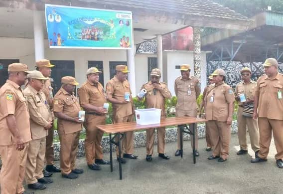Bupati Jayapura, Dr. Yunus Wonda, S.H., M.H., didampingi Plt. Sekda Kabupaten Jayapura, Dr. Yusup Yambeyabdi, S.T., M.T., dan sejumlah kepala perangkat daerah sedang mengeluarkan koin dari dalam celengan yang terkumpul dari setiap OPD usia Apel Rutin ASN di Lapangan Apel Gunung Merah Sentani. Senin (04/05/2026)
