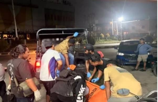 Polisi saat mengevakuasi jenazah korban.