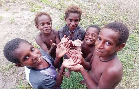 Anak-anak Kampung Wumuka menunjukan tangan yang bersih usai cuci tangan pakai sabun.