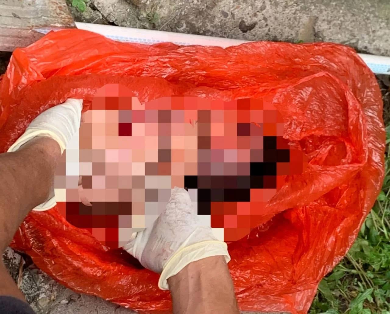 Tampak janin bayi berjenis kelamin laki-laki yang ditemukan warga dalam kantong plastik merah di Jalan Megantara, Timika, Senin (26/10) pagi.