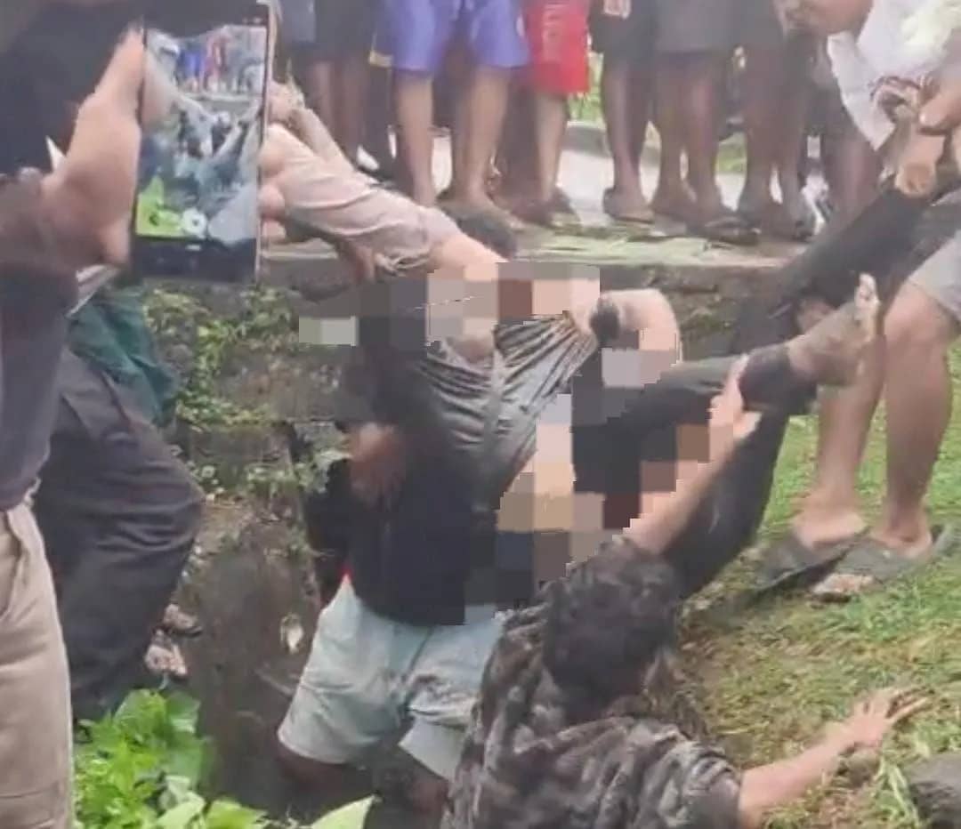 Jenazah Maikel saat dievakuasi warga dari Dalam selokan Jalan Budi Utomo Ujung Timika