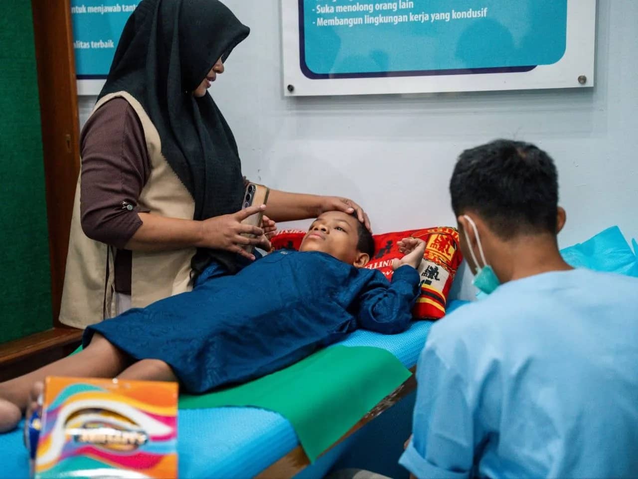 Orang tua mendampingi putranya selama proses khitan massal yang menjadi bagian dari program Muharram Berkah 1448 H. Program ini bertujuan membantu pemenuhan syariat Islam sekaligus meringankan beban ekonomi masyarakat.