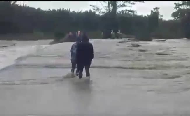 Warga mencoba melewati banjir yang menghancurkan jalan di Kilometer 12, sebelum PT PAL