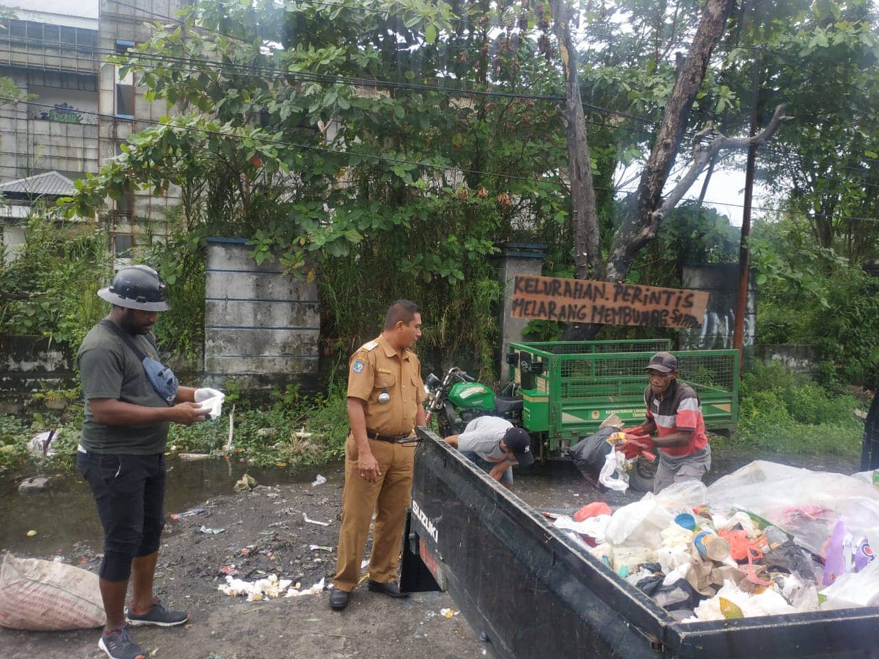 Kepala Kelurahan Perintis Yusran sedang mengawasi pembuangan sampah.