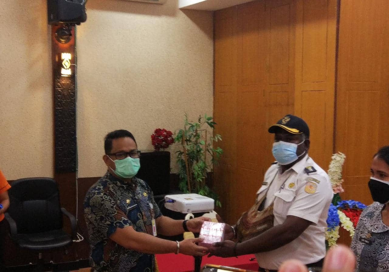 Sekda Kabupaten Mimika, Michael Gomar saat menyerahkan secara simbolis dana BST kepada salahsatu kepala distrik.
