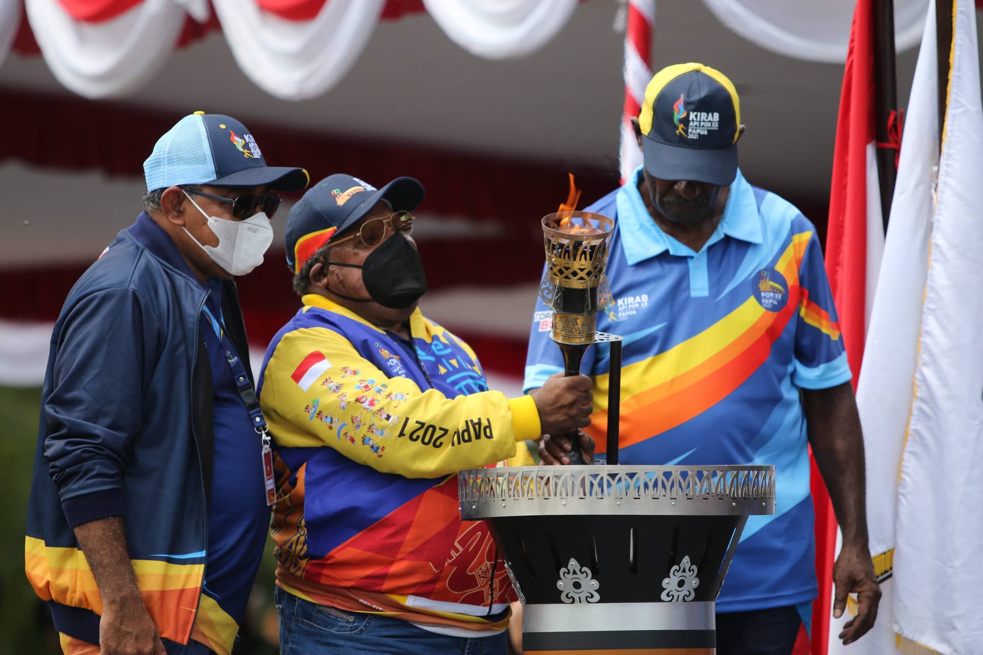 Bupati Mimika Eltinus Omaleng menyalakan api PON XX Papua 2021 setelah diserahkan oleh legenda atlet nasional sekaligus pemegang rekor nasional Dasalomba Yulius Uwe di Pendopo Rumah Negara Kabupaten Mimika, Papua, Selasa (28/9/2021). Foto: Humas PPM PB PON XX/Sevianto Pakiding