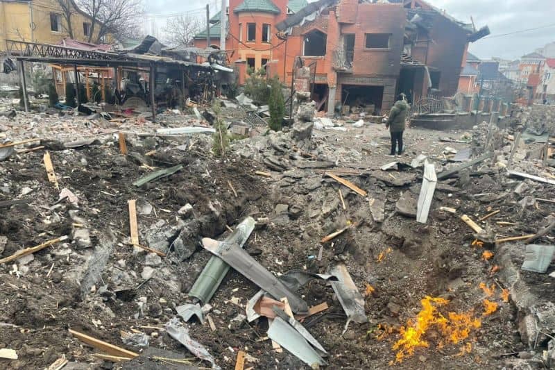 Puing-puing berserakan di sekitar lubang di sebuah jalan, tempat beberapa rumah rusak akibat ledakan, menyusul serangan udara di Bila Tserkva, Kyiv Oblast, Ukraina, Sabtu (5/3/2022).