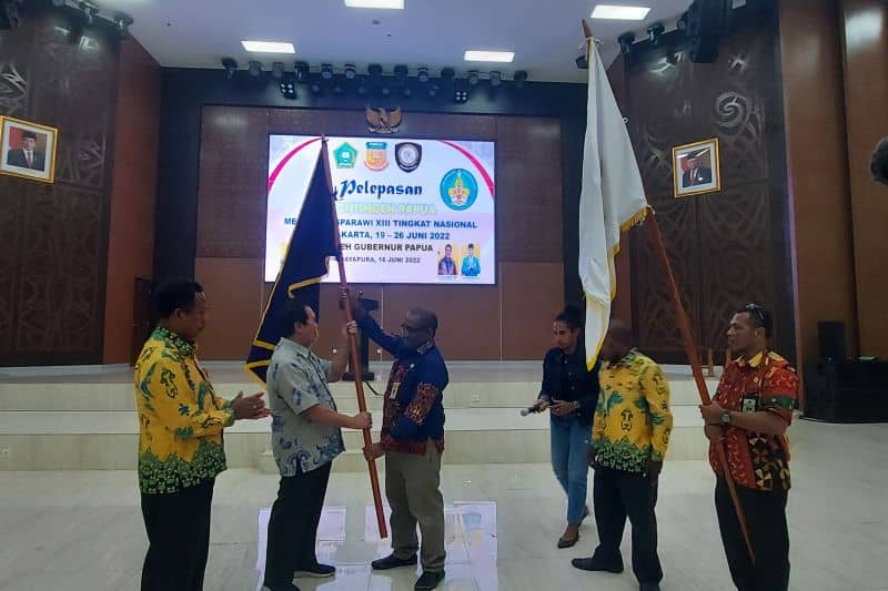 Pelaksana Tugas Asisten Bidang Umum Setda Papua Derek Hegemur memberikan pataka kepada Ketua LPPD Provinsi Papua Elia Loupatty di Jayapura, Kamis (16/6/2022).