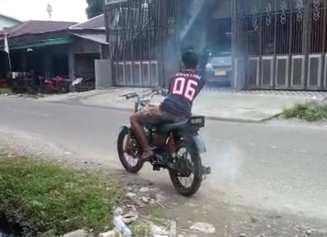 Seorang anak membunyikan knalpot racing di Jalan Serui Mekar