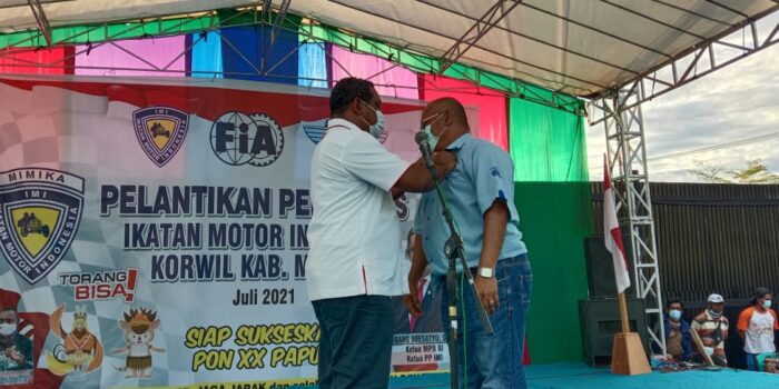 Pemasangan PIN KoNI oleh Sekum KONI kepada Ketua IMI Mimika
